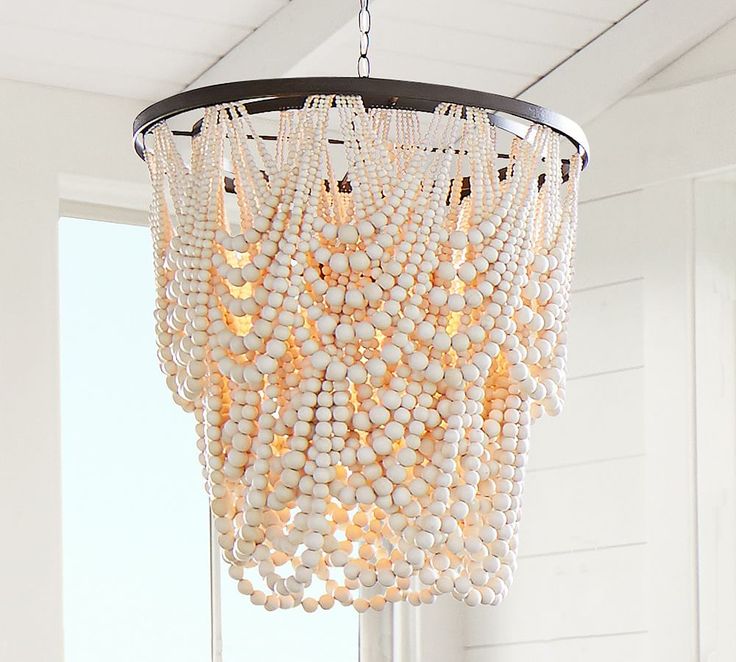 a chandelier hanging from the ceiling in a room with white walls and windows