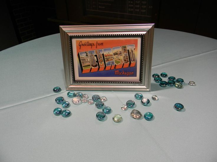 a table topped with lots of blue and white beads next to a framed picture on top of a table