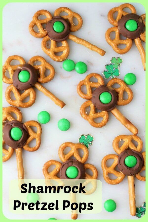 shamrock pretzel pops on a plate with green candies