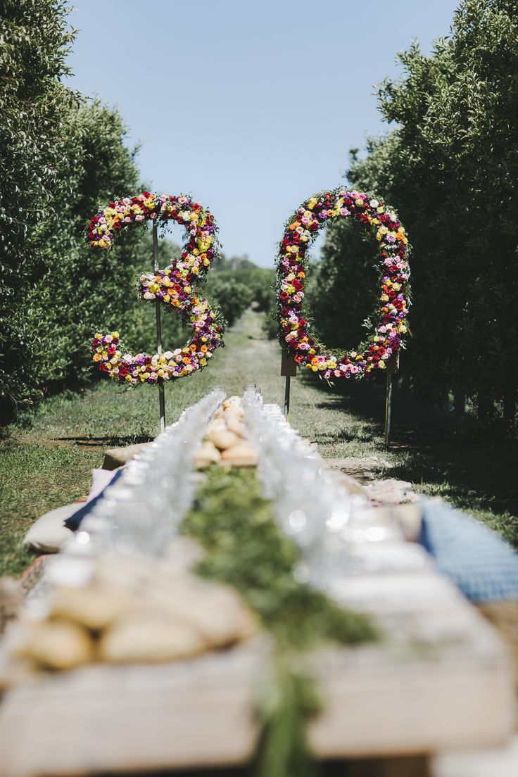 an outdoor table set up with food and flowers in the shape of o's