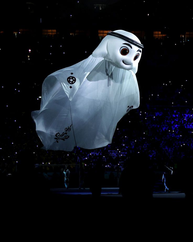 an inflatable ghost balloon is on display at a convention or show as people watch from the stands