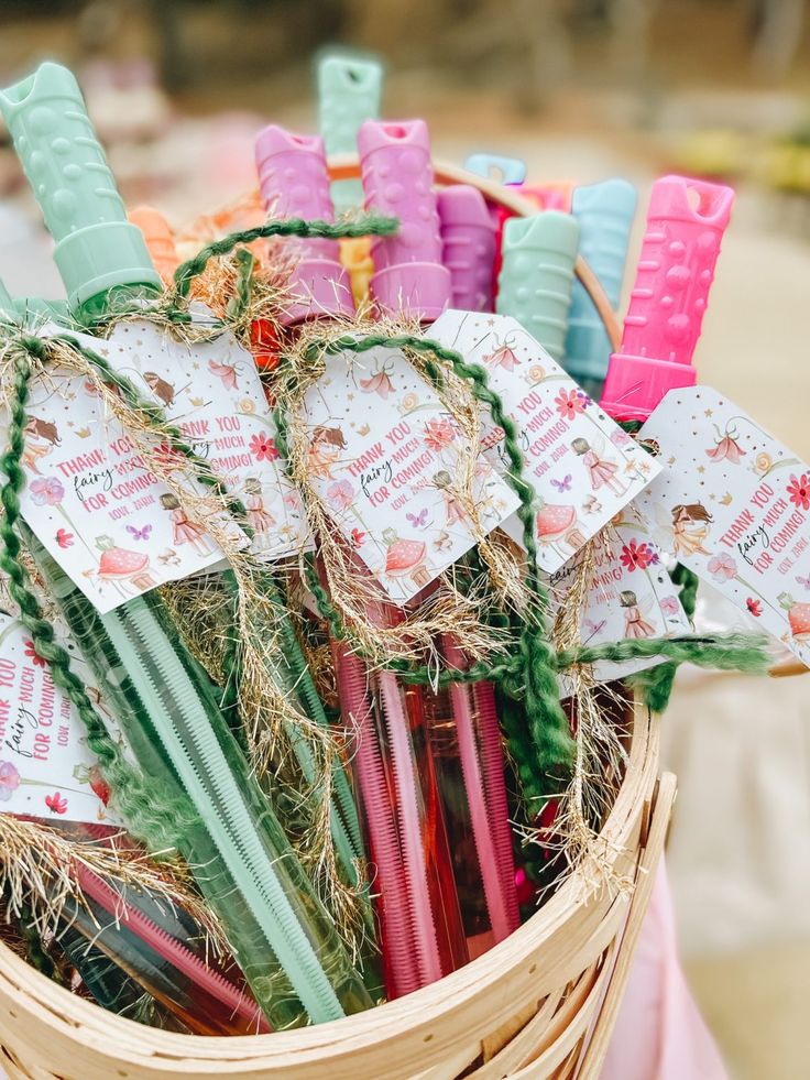 a basket filled with lots of different colored pens and paper tags on top of each other