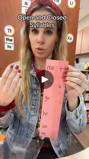 a woman holding up a pink piece of paper with words written on it that read open and closed syllables