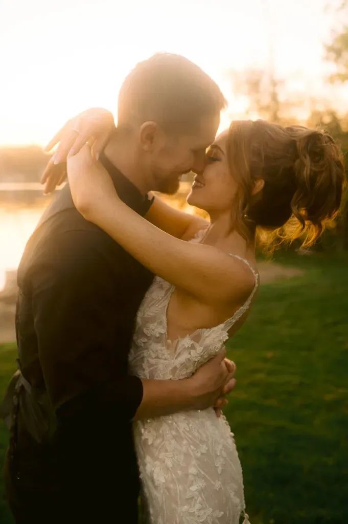 a bride and groom embracing each other in front of the water at their wedding reception