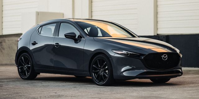 a gray mazda car parked in front of a building