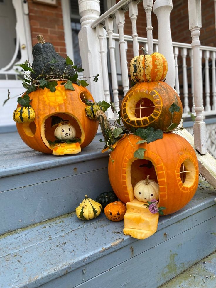 two carved pumpkins sitting on the steps with stuffed animals inside them and decorations around them