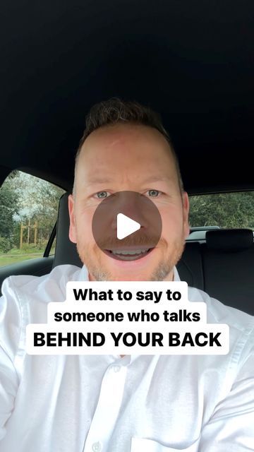 a man sitting in the back seat of a car talking to someone who talks behind him