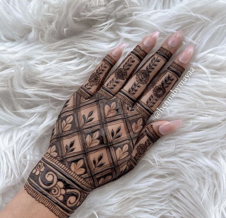 a woman's hand with henna tattoos on it