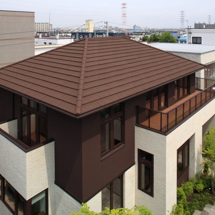 a brown and white building with lots of windows on the top floor is seen from above