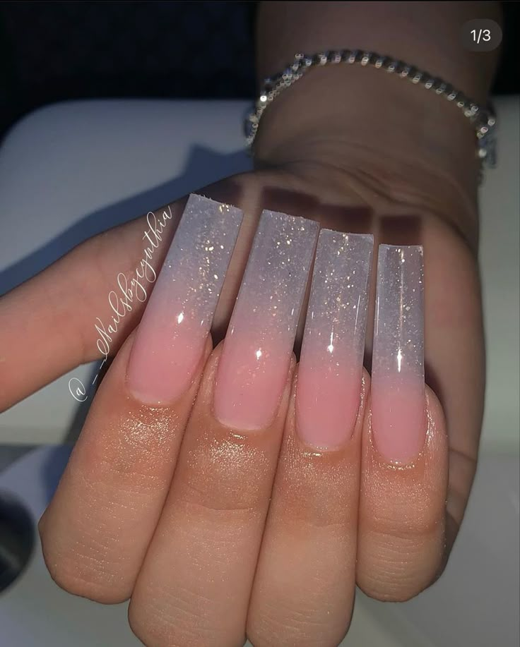 a woman's hand with pink and white ombreed nails