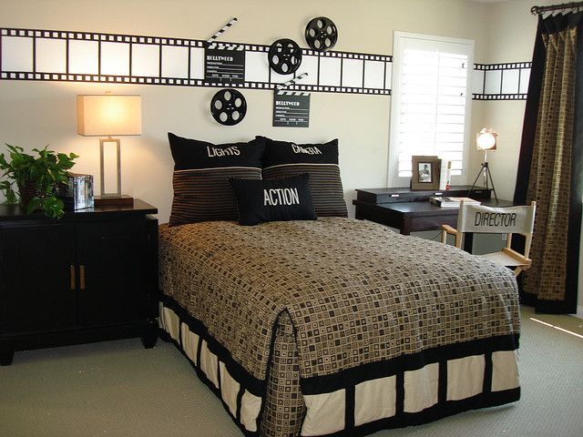 a bed with black and white comforter in a bedroom next to two lamps on either side of the bed