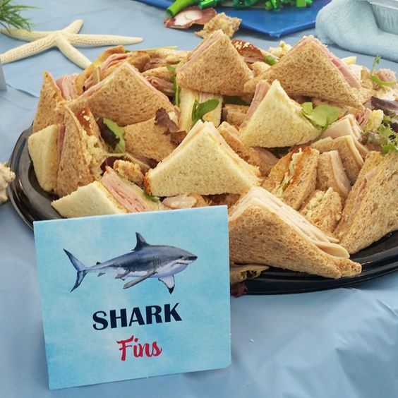 there is a shark sandwich on a plate with a sign in front of it that says shark fins