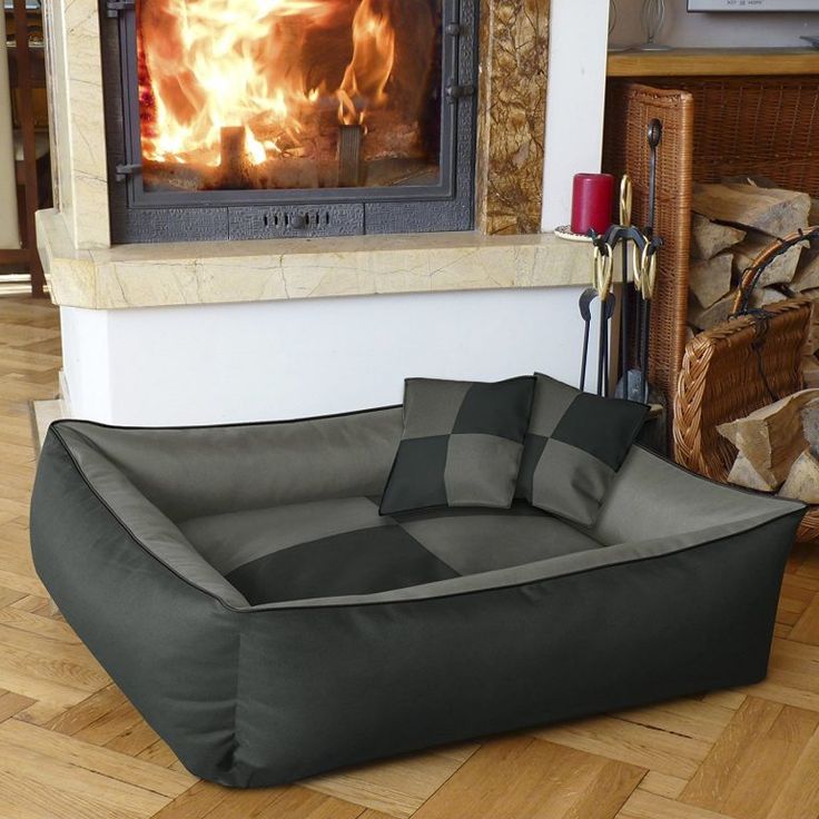 a dog bed sitting in front of a fire place