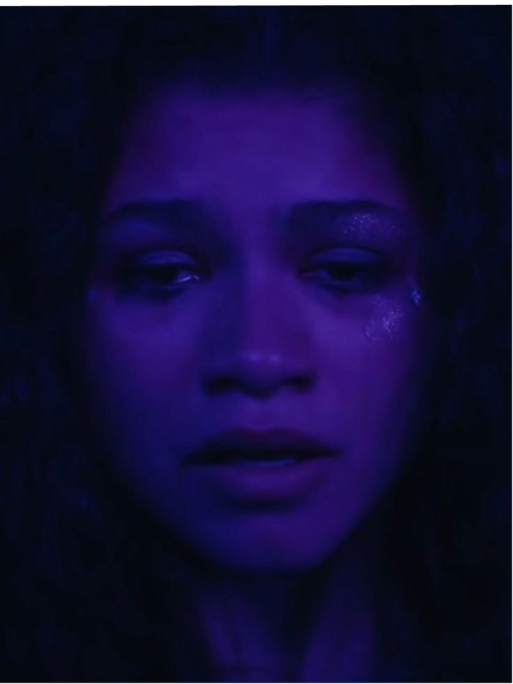 a woman with tears on her face in the dark