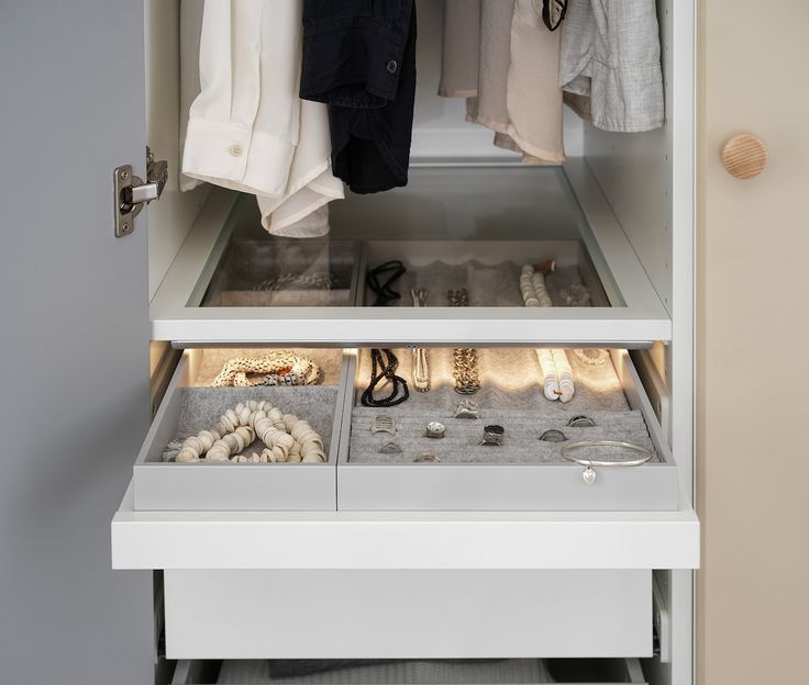 an organized closet with shoes and other items in the bottom drawer, including necklaces