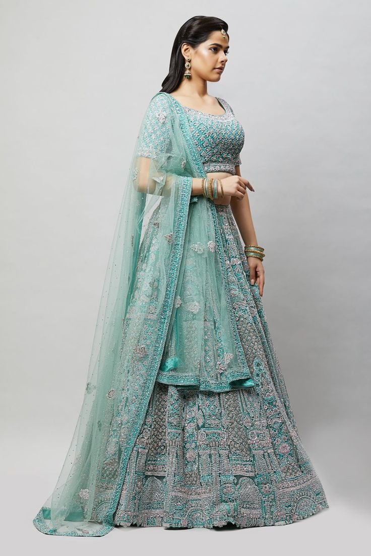 A beautiful sea green lehenga with tonal and silver stonework! Fabric: Net with satin lining All preorders will be handled by a Nazranaa Bridal Consultant who will virtually discuss measurements and minor changes according to the client's specifications Occasion: Wedding Reception WASH CARE INSTRUCTIONS - Please Dry clean only when it is applicable. Slight color variation is possible due to digital photography. Jewelry not included Designer Turquoise Embroidered Lehenga, Designer Embroidered Turquoise Lehenga, Turquoise Anarkali Sharara For Wedding, Anarkali Turquoise Sharara For Wedding, Wedding Anarkali Turquoise Sharara, Bollywood Style Turquoise Lehenga For Reception, Turquoise Bollywood Choli For Receptions, Bollywood Style Turquoise Choli For Reception, Bollywood Turquoise Choli For Reception