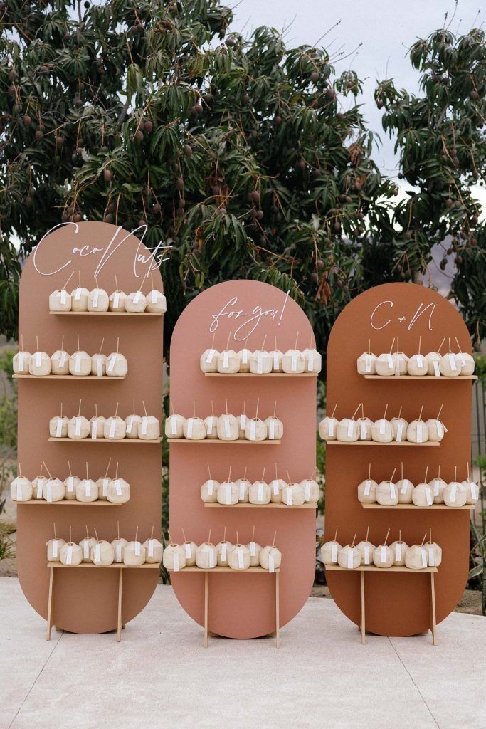 there are three tables with cupcakes on them in front of some trees and bushes