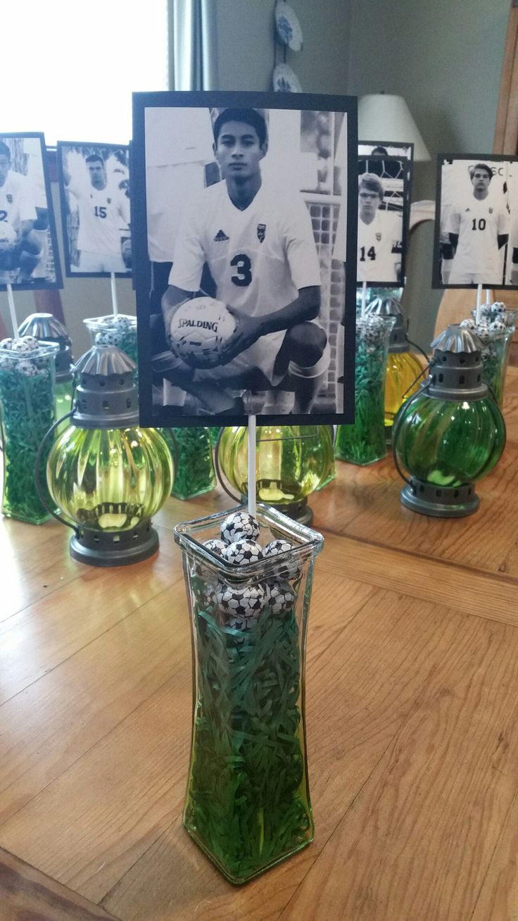 a table topped with vases filled with green liquid and pictures on the wall behind them