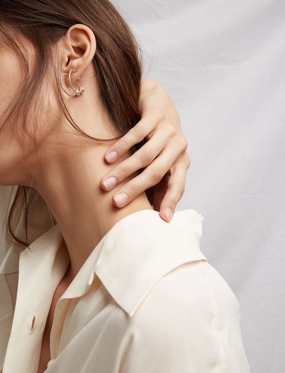 a woman with her hand on the back of her neck