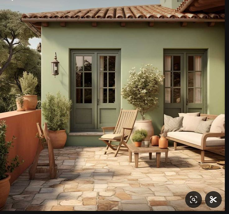 a patio with chairs, tables and potted plants in front of a green house