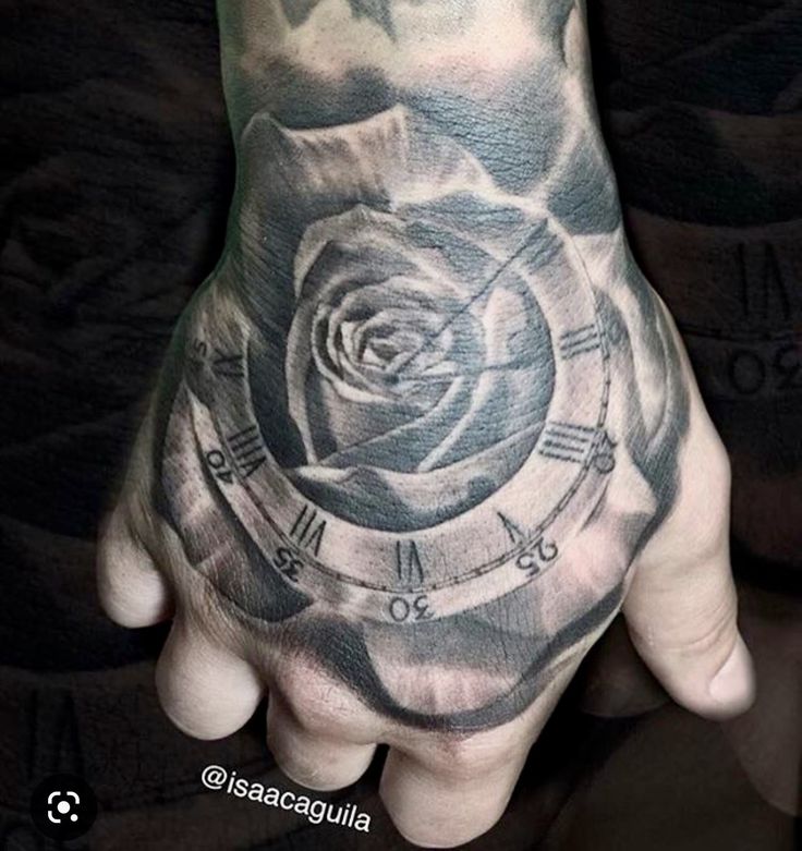 a man's hand with a rose and clock tattoo on the middle of it