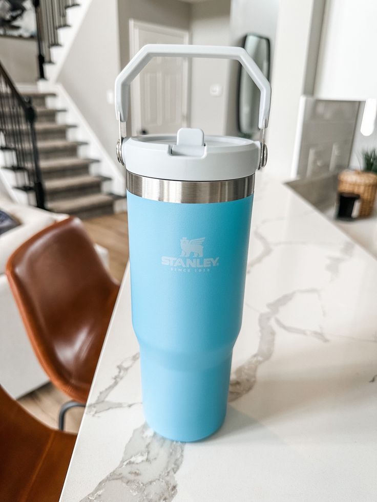 a blue yeti cup sitting on top of a table next to a brown chair