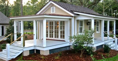 a small white house sitting on top of a lush green field