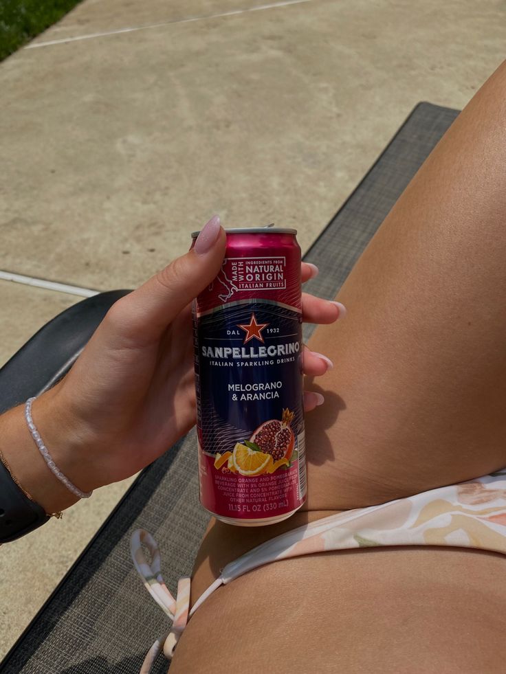 a woman holding onto a can of orange juice