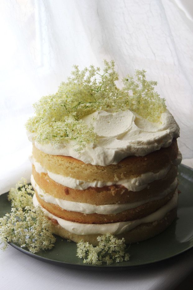 a layered cake with white frosting and green sprinkles on a plate