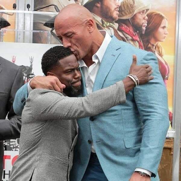 two men hugging each other in front of a movie poster