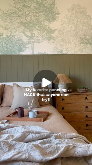 a bedroom with a bed, dresser and wallpaper on the walls that has trees painted on it