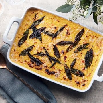 a casserole dish filled with food on top of a table next to silverware