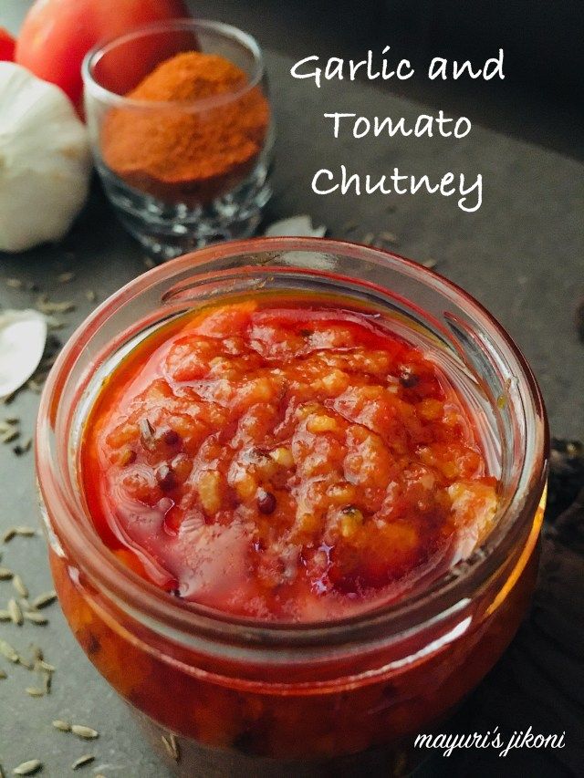 garlic and tomato chutney in a glass jar on a table with other ingredients