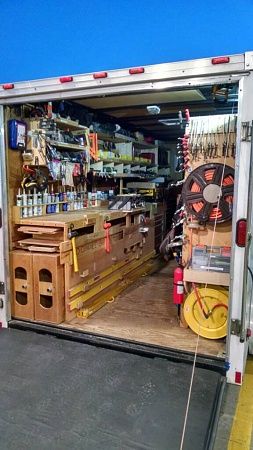 the back end of a truck with its door open and tools in it's storage area