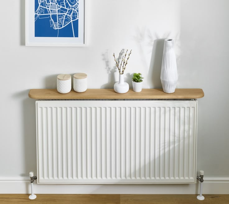 a white radiator and some vases on a wooden table in a room