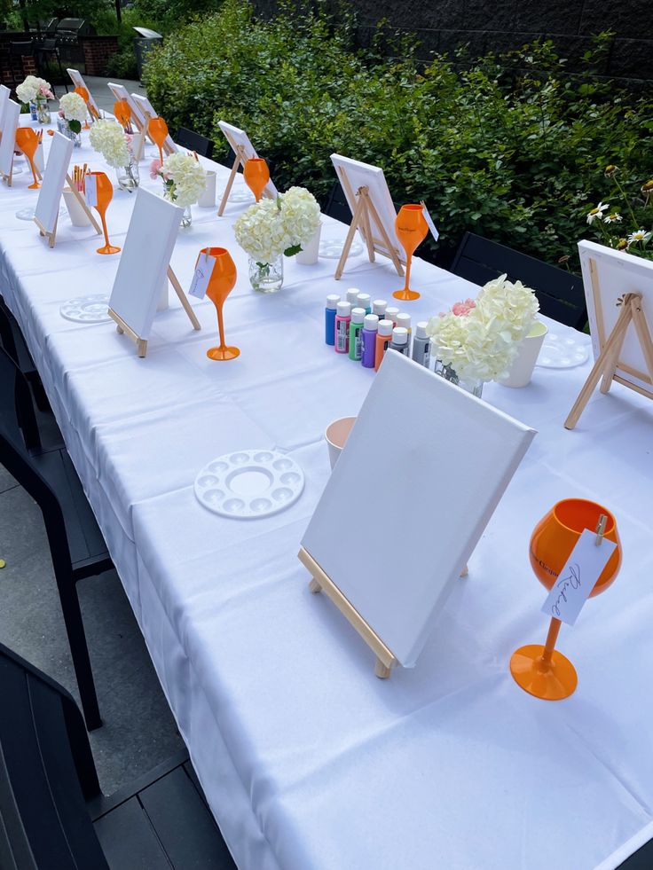 a long table with an easel and flowers on it is set up for a wedding reception