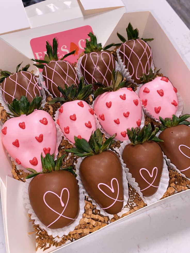 chocolate covered strawberries in a box with hearts on them