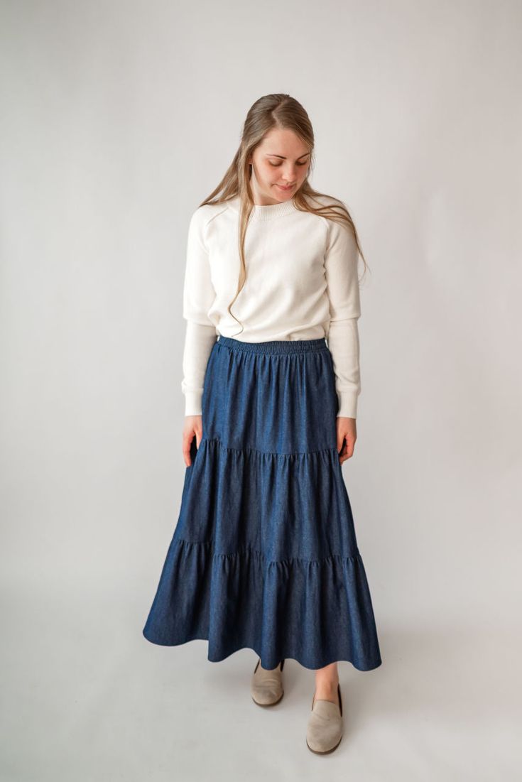 Perfect for a spring picnic or an everyday morning, the 'Celeste' skirt is so lovely and versatile! Constructed from lightweight cotton denim for a comfortable fit that moves with you, this skirt features hidden side pockets and an elastic waistband. Falling in ankle-length tiers, this comfortable skirt will compliment any simple top. Fit: true to size! Style: functioning pockets, elastic waist, tiered Color: dark wash Fabric content: 100% cotton Care instructions: wash gentle cycle, cold; lay f Spring Picnic, Comfortable Skirts, Be Intentional, Simple Top, Modest Clothing, Garment Labels, Tier Skirt, Curated Gifts, Tiered Skirt