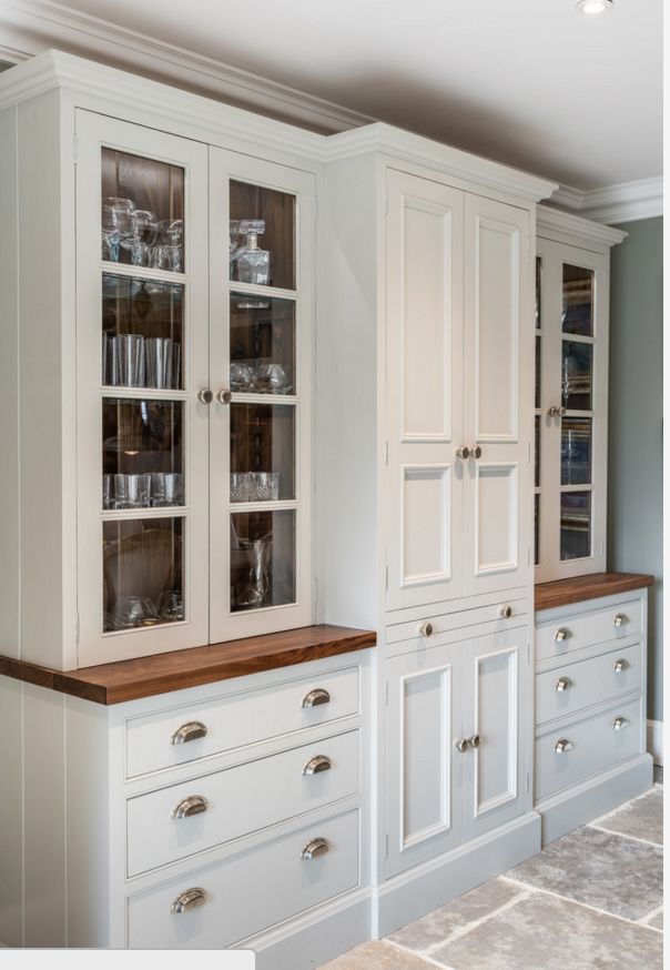 a kitchen with white cabinets and wooden counter tops