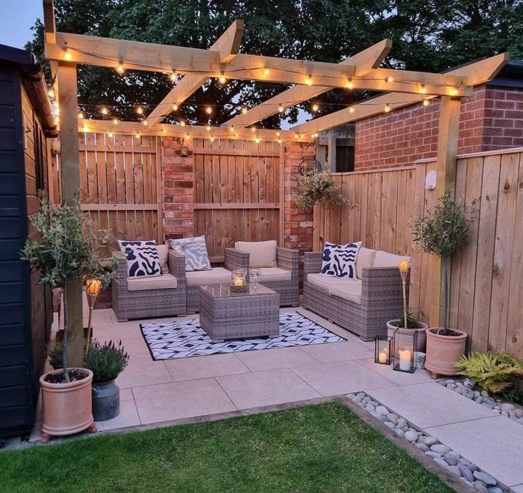 an outdoor living area with patio furniture and string lights on the pergolated roof