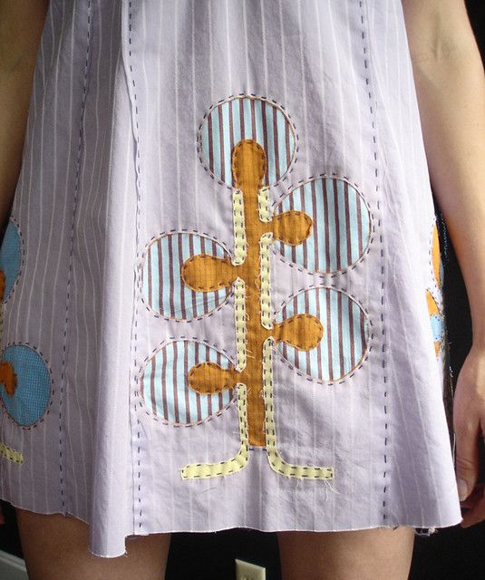 a close up of a woman's skirt with an embroidered design on it and the bottom part of her pants