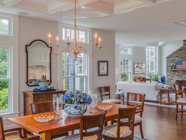 a dining room table and chairs in front of windows