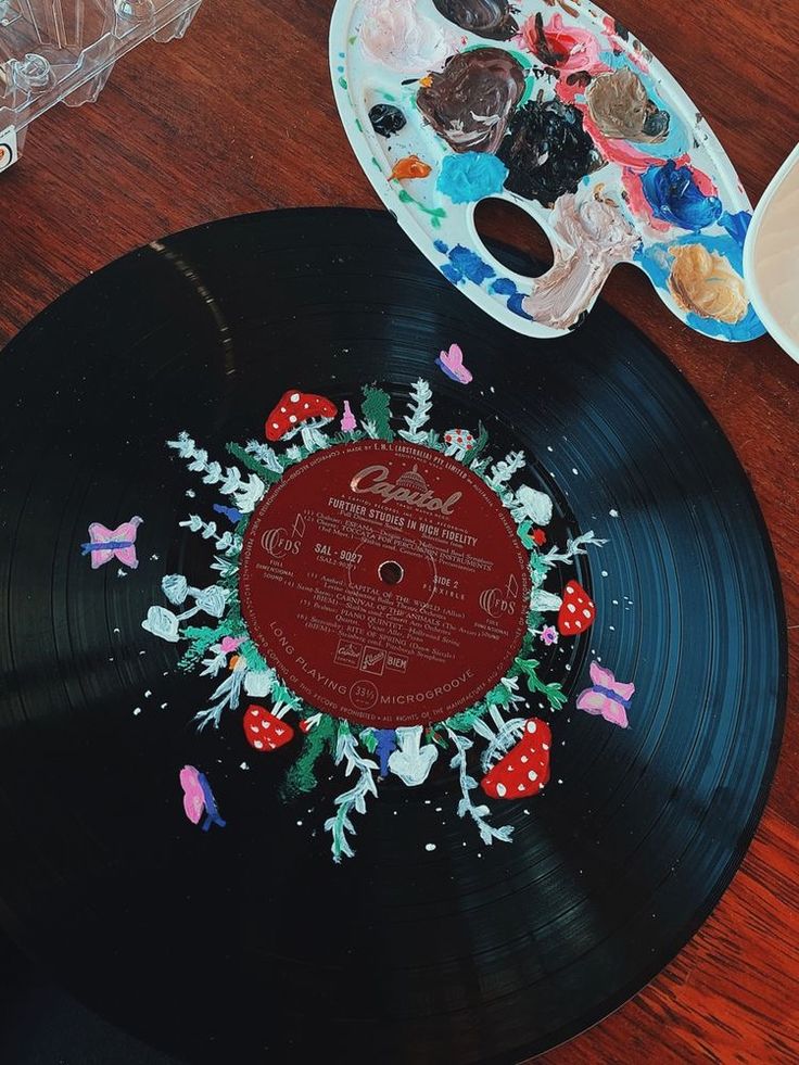 an old record sitting on top of a wooden table next to a bowl of food