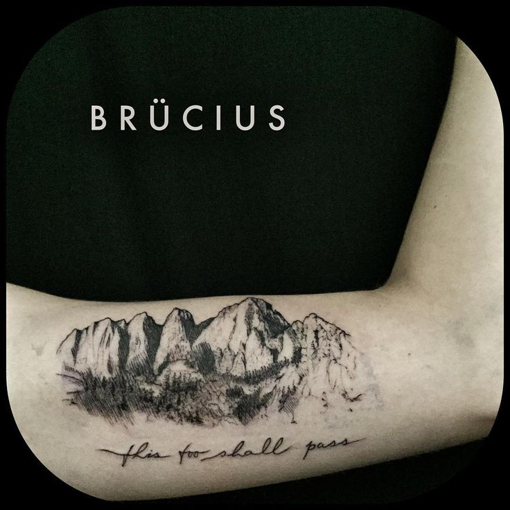 a man's arm with a mountain tattoo on it and the words brucus written in cursive writing