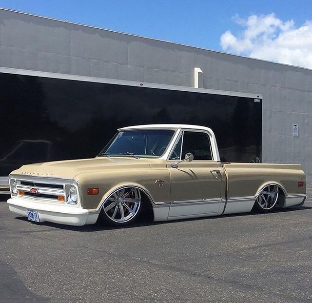 an old pickup truck parked in front of a garage