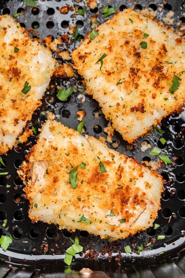 four pieces of chicken cooking in a frying pan with herbs on the top and bottom