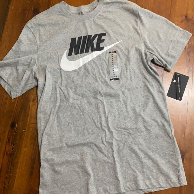 Grey Nike Logo Tshirt Casual Cotton T-shirt In Athletic Heather, Gray Crew Neck Top With Logo Print, Nike Athletic Heather Crew Neck T-shirt, Casual Nike Crew Neck T-shirt, Nike Cotton Tops For Spring, Basic Gray Top With Logo Print, Gray Cotton Shirt With Logo Print, Tan Cotton Shirt With Logo Print, Nike Cotton Crew Neck Shirt