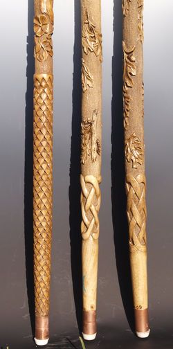 three carved wooden poles sitting next to each other