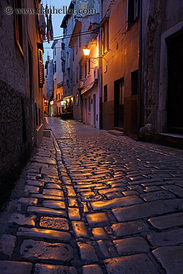 a cobblestone street at night in an old town