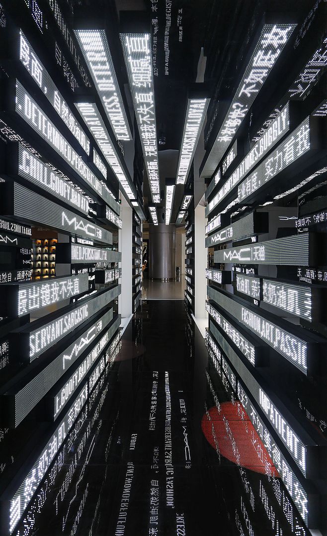 an empty hallway with lots of black and white letters all over the floor, along with lights on either side of the wall